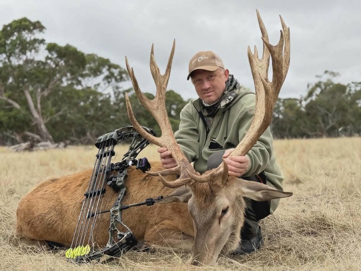 Hunter with a red stag taken with 3K woven carbon shafts and flo-yellow fletching