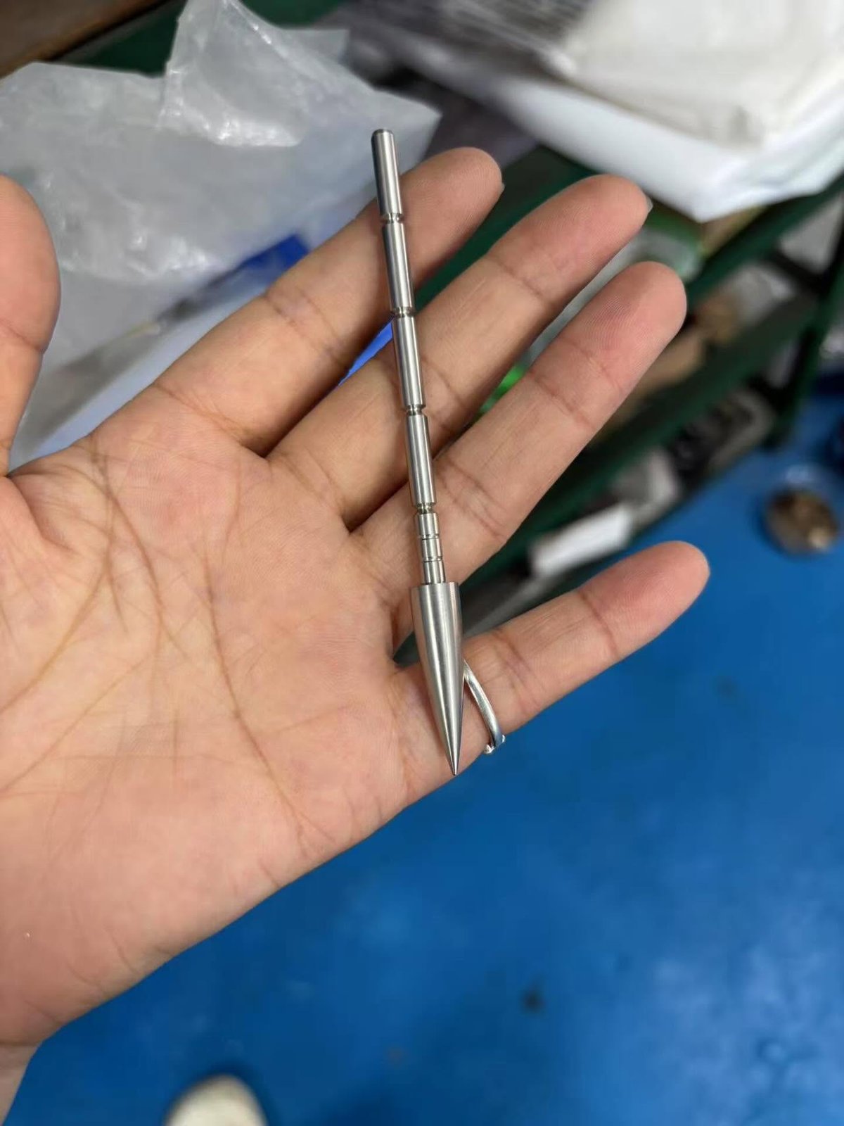 Custom glue-in point held in hand at the factory